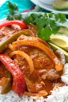 a plate with rice and peppers on it, next to cucumbers and avocado