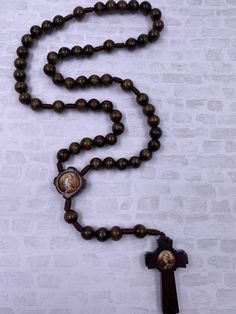 Modest yet intricate, this hand made and assembled wooden bead rosary is a great find for any form of worship or prayer. With depiction of Benedict of Nursia in sepia, who founded the Benedictine monks, a religious order which thrives throughout the world to this day. An inspiring and thoughtful gift for guys or girls on any occasion, it makes a stylish accessory wherever it goes. Rosario hecho a mano de madera y hilo con imagen de Santo Benito. Handmade Brown Spiritual Rosary, Adjustable Brown Wooden Beads Rosary, Adjustable Brown Wooden Bead Rosary, Adjustable Brown Wooden Rosary, Adjustable Brown Beads For Crafting, Traditional Beaded Brown Rosary, Traditional Handmade Brown Rosary, Traditional Brown Beaded Rosary, Traditional Adjustable Brown Rosary