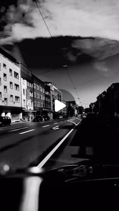 a black and white photo of a city street with buildings on both sides of the road