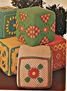 three crocheted boxes with flowers and leaves on them sitting next to each other