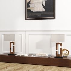 two lamps are sitting on a shelf in front of a painting