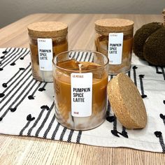 three jars filled with liquid sitting on top of a table next to an avocado