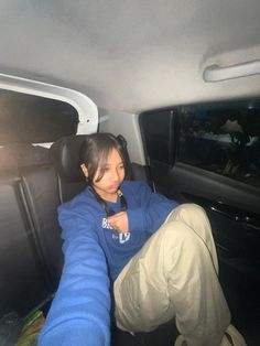 a woman sitting in the back seat of a car