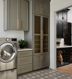 a washer and dryer in a room with cabinets on either side of the door