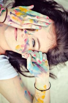 a woman with painted hands covering her face