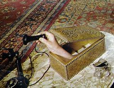 a person is holding a video game remote control in a box on the floor next to a rug