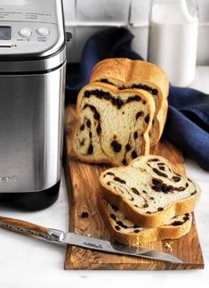 a loaf of bread sitting on top of a cutting board next to an air fryer