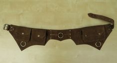 a brown leather belt with metal buckles on the sides and two holes in the middle