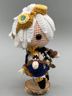 a crocheted doll is holding a bagpipe and wearing a white turban