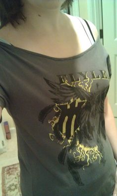 a woman is taking a selfie in the mirror with her cell phone and wearing a t - shirt with an eagle on it