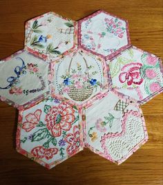 four hexagons with different designs on them sitting on a wooden table top