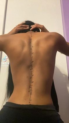 the back of a woman's body with her hand on her head and writing on it