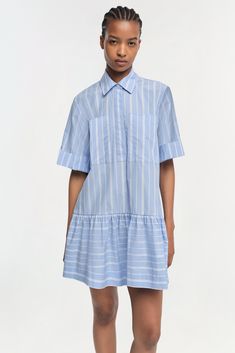 COTTON POPLIN CAPSULE The Cris Dress in Wide Oxford Blue Stripe. Crafted from lightweight fabric, this charming top features a soft blue and white striped pattern that evokes a fresh, summery feel. The shirt dress is designed with a traditional pointed collar and a button-down front that provides a classic touch, while the short sleeves add a casual, airy quality. Blue Stripe Dress, Cotton Poplin Dress, English Factory, Oxford Blue, Lee Cooper, Cotton Poplin Fabric, Blue Striped Dress, Poplin Dress, Stripe Dress