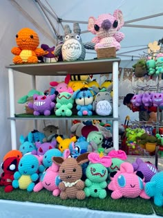 there are many crocheted stuffed animals on the shelves in this tented area