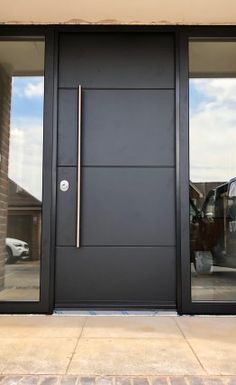 the front door to a building with two glass doors and one has a metal handle on it