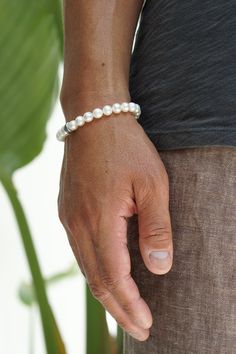 Featuring premium Freshwater Pearls, sterling silver hardware and a single Maya David silver bead, this bracelet combines classic elegance with a modern edge. A must-have in any man's jewelry collection. Sterling Silver Freshwater Pearls 7mm Thickness Push Clasp Handcrafted in LA Pair with our Men's Pearl Necklace Determining your bracelet size: Encircle your wrist with a flexible tape measure and record the measurement. Because of the larger pearl size, add 3/4 to 1 inch to your wrist measureme Mens Pearl Necklace, Pearl Jewelry Gift, Stacked Jewelry, Silver Bead, Gold Collection, Pearl Size, Tape Measure, Classic Elegance, Bracelet Sizes