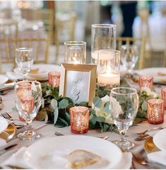 the table is set with candles, plates and place settings for an elegant wedding reception