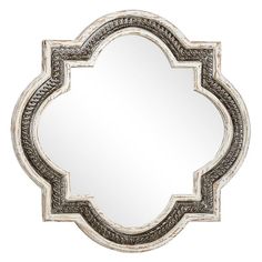 a decorative mirror with an ornate design on the front and back side, in silver