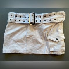 New With Tag White Denim Mini Skirt 100% Cotton Silver Tone Hardware Has Pockets Applied On Top Like Cargo Pants Or Painters Pants With Snap Closure Belt Design Has Grommets Condition: Under The Belt Buckle, On The Skirt Is Some Smudge. I Was Not Able To Wash Without Taking Off Tags. However, Smudge Will Not Show With Belt On And Very Likely Smudge May Come Off With Wash. Resting Measurements Waist Side To Side: 15” Waist To Hem: 12” White Denim Mini Skirt, Style Mini Skirt, Painters Pants, Denim Cargo, Belt Design, Cargo Style, Denim Mini, Denim Mini Skirt, White Denim