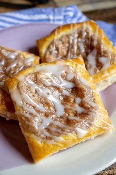 three cinnamon rolls with icing on a plate