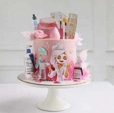 a pink cake decorated with various beauty products