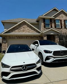 two white cars parked in front of a house