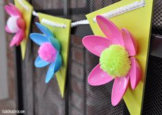 colorful paper flowers are hanging on the clothes line