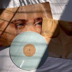 an image of a woman's face on top of a white record player and album