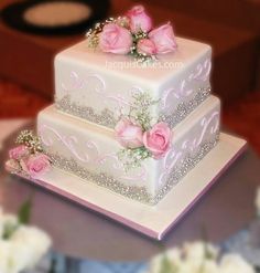 two tiered wedding cake with pink roses on the top and silver bling around the edges