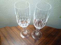 two wine glasses sitting on top of a wooden table