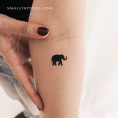 an elephant tattoo on the arm of a woman's left calf, which is black and white