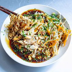 a white bowl filled with noodles and meat