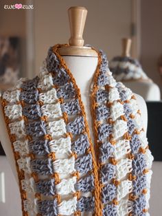 a crocheted scarf is displayed on a mannequin