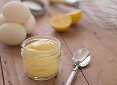 a jar of mayonnaise sitting on top of a wooden table next to eggs