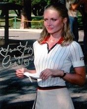 a woman holding a paper in her right hand while standing next to a sign with writing on it