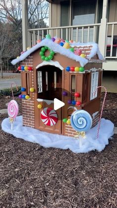 a gingerbread house with candy and lollipops in the front yard for christmas