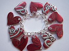 red and white heart shaped charms are on a silver plated bracelet that is attached to a chain