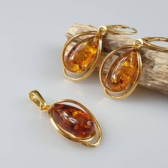 Brown amber set. Beautiful natural cognac Baltic Amber SET (Earrings + Pendant). Handmade of brown Baltic Amber. Gold plated - with hallmarks. Weight: pendant 2,54 gr Earrings 5,63 gr Length: pendant size 3,5 x1,6 cm , Earrings length 4 cm Matching ring: https://www.etsy.com/uk/listing/932778160/amber-ring-gold-plated-ring-natural?ref=shop_home_active_16&pro=1&frs=1 This item was made of natural Baltic Amber. All the amber used in my jewelry is collected in my home country Lithuania. I sell only Luxury Gold Baltic Amber Jewelry, Luxury Gold Plated Amber Jewelry, Luxury Amber Jewelry With 8mm Beads, Luxury Amber Necklaces Fine Jewelry, Luxury Artisan Amber Jewelry, Luxury Elegant Amber Necklaces, Elegant Luxury Amber Necklaces, Amber Ring Gold, Small Gold Earrings