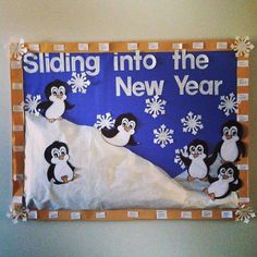 a bulletin board with penguins and snowflakes on it that says sliding into the new year