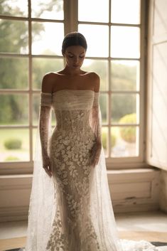 a woman in an off the shoulder wedding dress