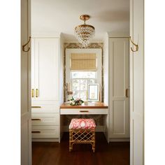 a room with a desk, chair and mirror on it's wall in front of a window