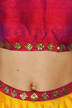 This lehenga choli components a yellow, hot pink and maroon crude silk lehenga with crisscross print and gota lines all over and sequins weaved waistband. It has an underlayer of can-can. It is matched with maroon crude silk pullover with gold sequins weaving in precious stone example on the neck area and fix and curtail. It likewise joins pink sequins weaved net dupatta. Pink Raw Silk Choli For Navratri, Festival Raw Silk Choli With Mirror Work, Pink Lehenga With Motifs For Navratri, Bollywood Pink Sharara With Motifs, Pink Bollywood Silk Choli, Festival Pink Raw Silk Pre-draped Saree, Pink Navratri Sharara With Motifs, Navratri Party Lehenga With Motifs, Anarkali Choli With Pink Motifs