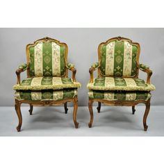 a pair of chairs with green and white upholstered fabric on the back, sitting side by side