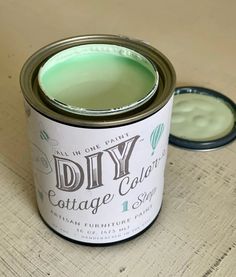 a can of paint sitting on top of a wooden table next to a small container