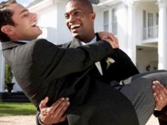 two men in suits and ties are hugging each other outside the white house with their arms around one another