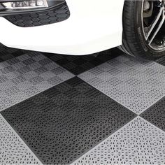 a white car parked on top of a black and white checkered tile flooring