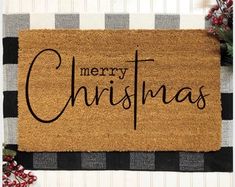 a merry christmas door mat with the words merry christmas on it next to holly wreaths