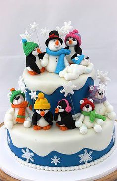 a birthday cake decorated with penguins and snowflakes