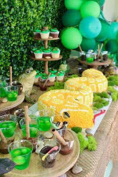 a table topped with lots of green desserts and cupcakes on top of plates