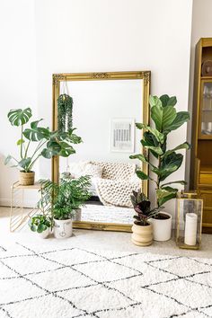 a man and woman sitting on a couch in front of a mirror with potted plants